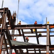 Construction workers assembling the frame of a building.