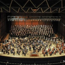 A symphony orchestra performing together on a concert stage