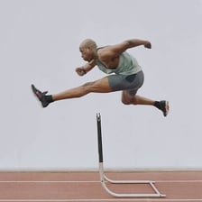 A person leaping over a hurdle in a vaulting movement