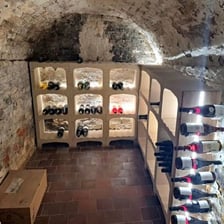 A below-ground stone cellar lined with storage shelves