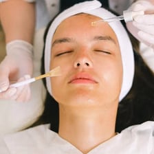 A person receiving a facial treatment at a spa