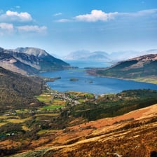 A green Scottish glen between mountainous slopes.
