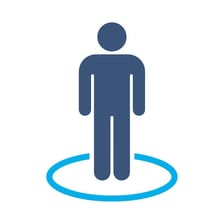 A person standing beside a sign indicating a location.