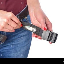 A person discreetly putting money into a pocket.