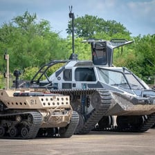 A tracked armoured military tank in the field.