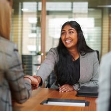 An employer speaking with a worker in an office