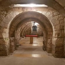 An underground stone crypt beneath a church, with chapel-like features.