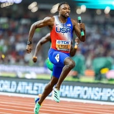 A sprinter running on an athletics track.