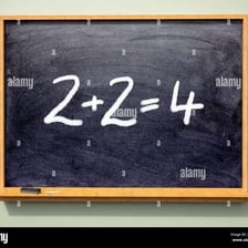 A classroom blackboard showing numbers being added to find a sum.