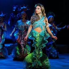 A young female stage character portrayed in an innocent theatrical style