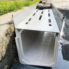 A long narrow drainage ditch beside a road