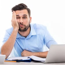 A tired person looking bored during a tedious task.