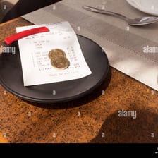 Money left as a gratuity beside a restaurant bill