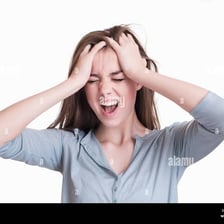 A person holding their head because of a headache.