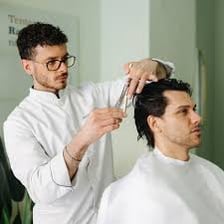 A barber cutting a man's hair.