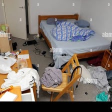 Room with clothes and objects scattered around in visible disarray