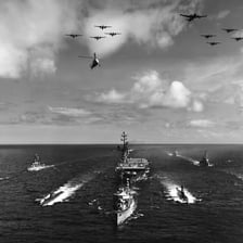 A formation of naval ships sailing at sea.