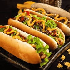 A hot dog sausage served in a bun with mustard