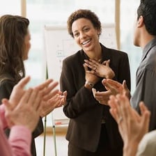 An audience applauding a person being publicly praised.