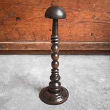A traditional old-fashioned hat displayed on a stand