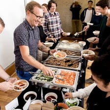 Catering staff serving food at a buffet.