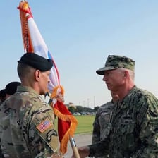 A military officer giving instructions to a group of soldiers.