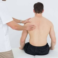 An osteopath manually treating a patient's back.