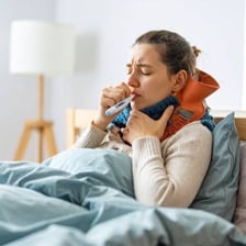 A person resting with symptoms of fever and chills