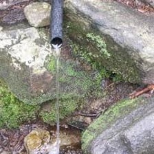 A stream emerging from its source in a mountainous landscape