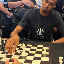 Two chess players opposing each other across a chessboard