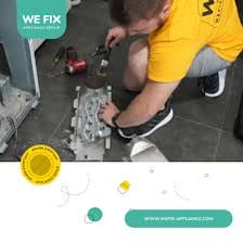 A technician repairing an appliance with hand tools.