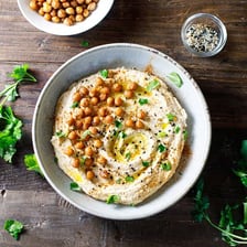 Chickpeas beside a bowl of hummus.