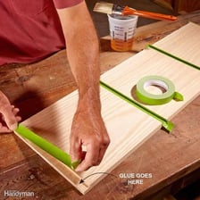 A person joining two pieces of material with glue.