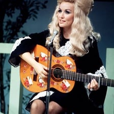 A singer performing a gentle romantic song with a guitar