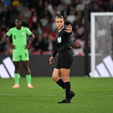 Match referees officiating on a football field.