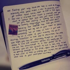 A person looking sadly at a love letter, suggesting heartbreak.