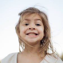 A young child standing outdoors.