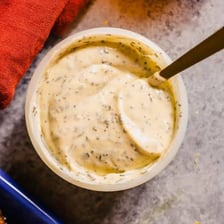 A bowl of pale aioli garnished and served as a dipping sauce