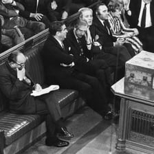 Members of a parliamentary chamber applauding a speaker.