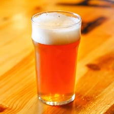 A pint of amber ale in a beer glass.