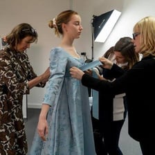 A costume designer working among theatrical garments
