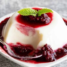 A moulded white blancmange dessert served on a plate.