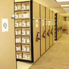Shelves containing labelled archival boxes and records.