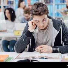 A student studying from books at a desk.