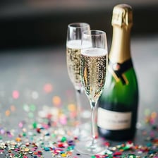 A bottle of champagne beside filled champagne glasses