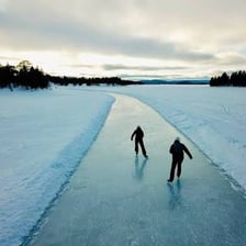 A bladed ice skate resting on a sheet of ice