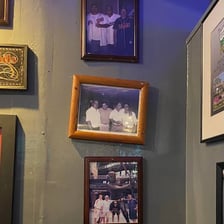 A picture frame hanging noticeably crooked on a wall.