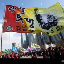 A trade union demonstrator holding a union flag at a rally.