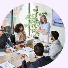 People seated around a boardroom table at a management meeting