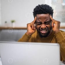 A person showing distress by holding their head.